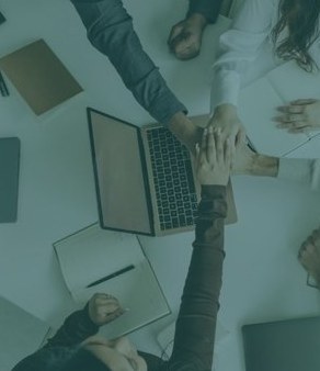 Mains réunies de l'équipe autour d'une table de travail